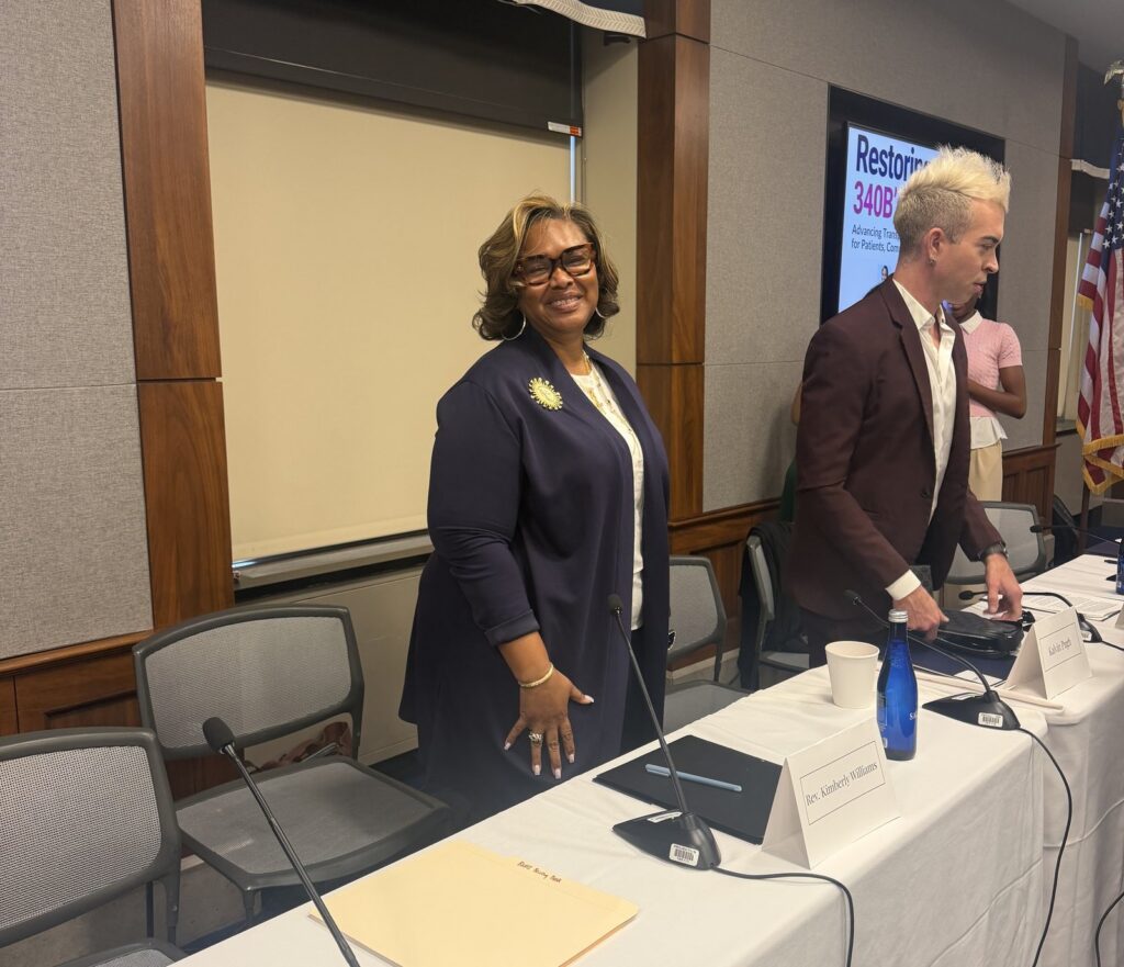 Rev. Kimberly L. Williams smiling at the panel table after the briefing